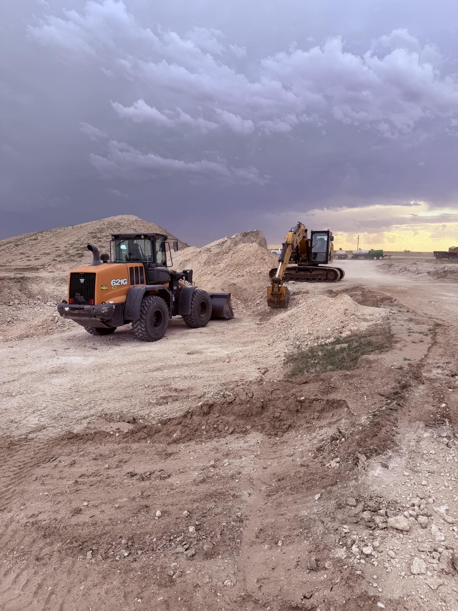 Loader and excavator on dirt